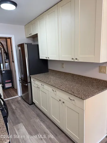 a kitchen with granite countertop a sink a refrigerator and cabinets