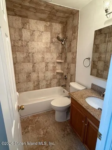 a bathroom with a granite countertop toilet a sink and bathtub