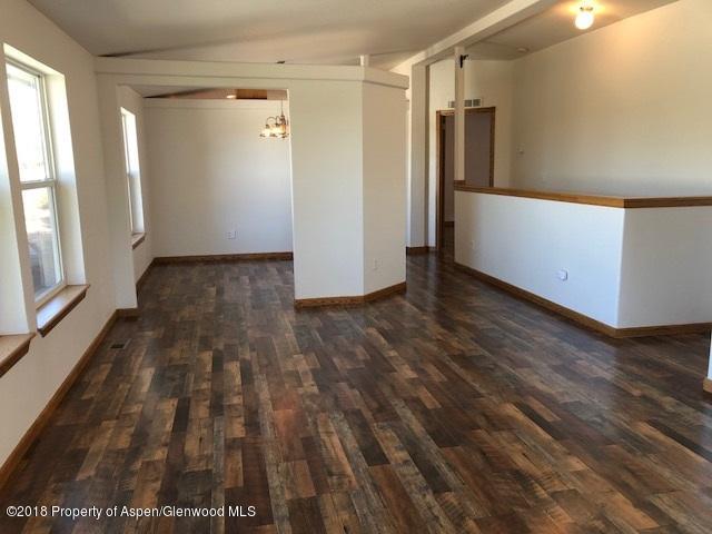 414 East 7th Street Rifle, CO 81650 - Photo 2 of 20 a view of an empty room with wooden floor and a window