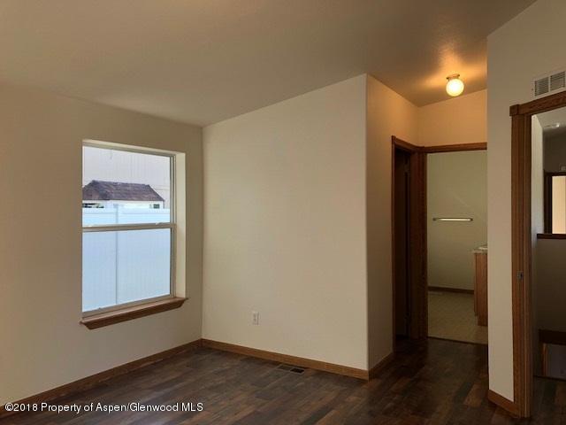 414 East 7th Street Rifle, CO 81650 - Photo 5 of 20 a view of an empty room with wooden floor and a window