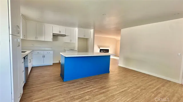 a view of kitchen with wooden floor and electronic appliances