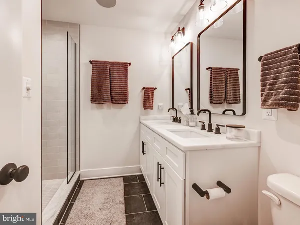 a bathroom with a sink and mirror with toilet
