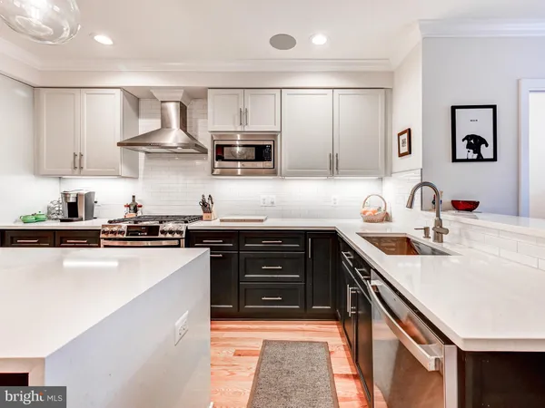 a kitchen with stainless steel appliances a sink stove and cabinets