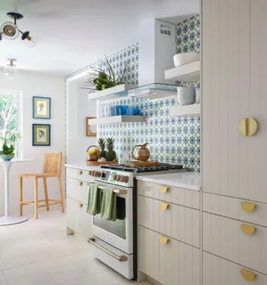 a kitchen with stainless steel appliances a stove and white cabinets