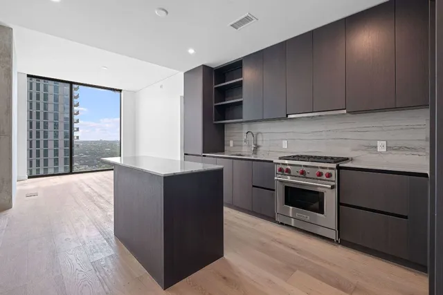 a kitchen with stainless steel appliances granite countertop wooden cabinets and a stove top oven