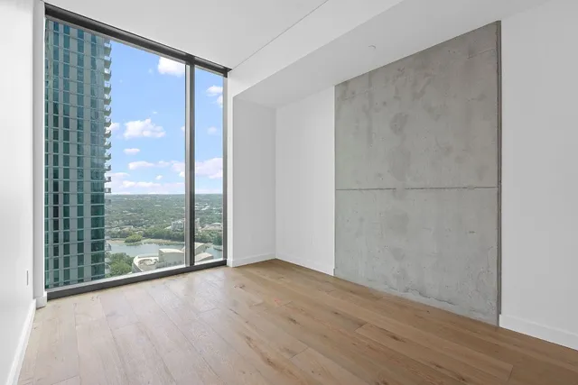 a view of a big room with wooden floor and windows