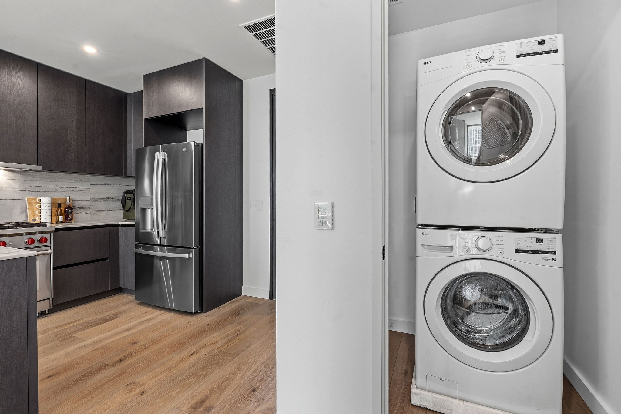 610 Davis Street, Unit 3004 Austin, TX 78701 - Photo 15 of 40 Laundry area with stacked washer / drying machine, light wood-style flooring, and recessed lighting