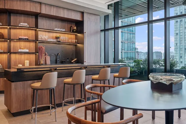 a dining room with furniture and a floor to ceiling window