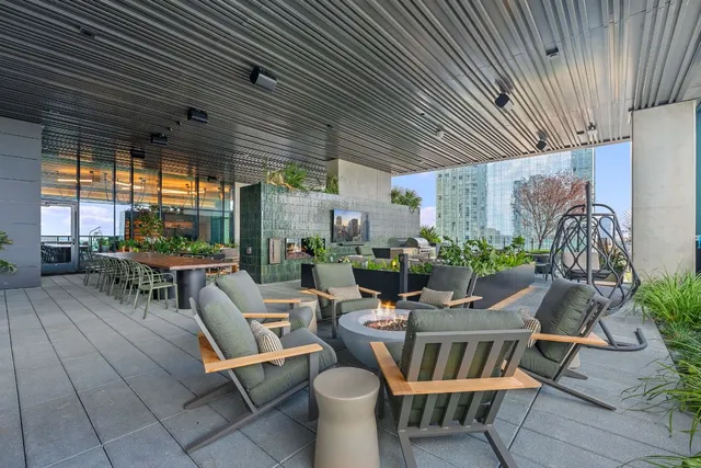a view of a patio with table and chairs potted plants and floor to ceiling window