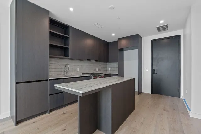 a kitchen with stainless steel appliances granite countertop a refrigerator a sink and a stove