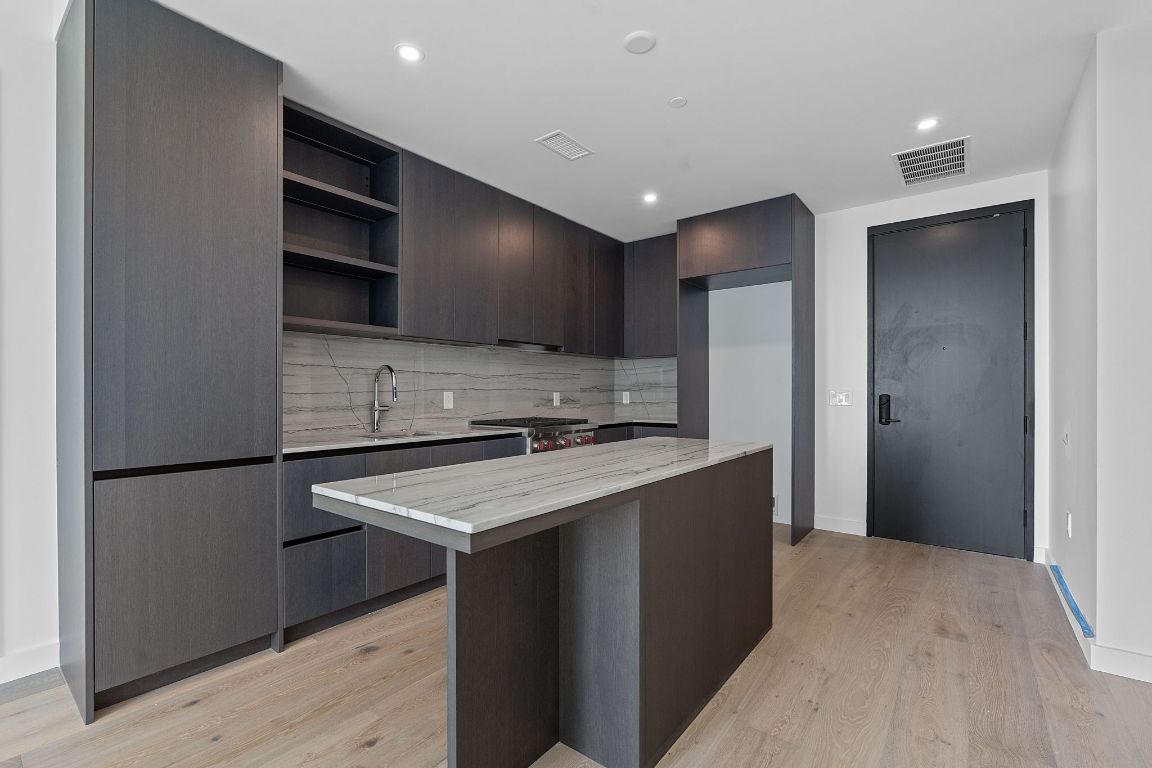 610 Davis Street, Unit 3004 Austin, TX 78701 - Photo 5 of 40 a kitchen with stainless steel appliances granite countertop a refrigerator a sink and a stove