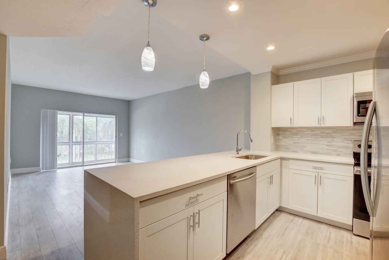 290 West Palmetto Park Road, Unit 304 Boca Raton, FL 33432 - Photo 1 of 27 a kitchen with a sink white cabinets and white appliances