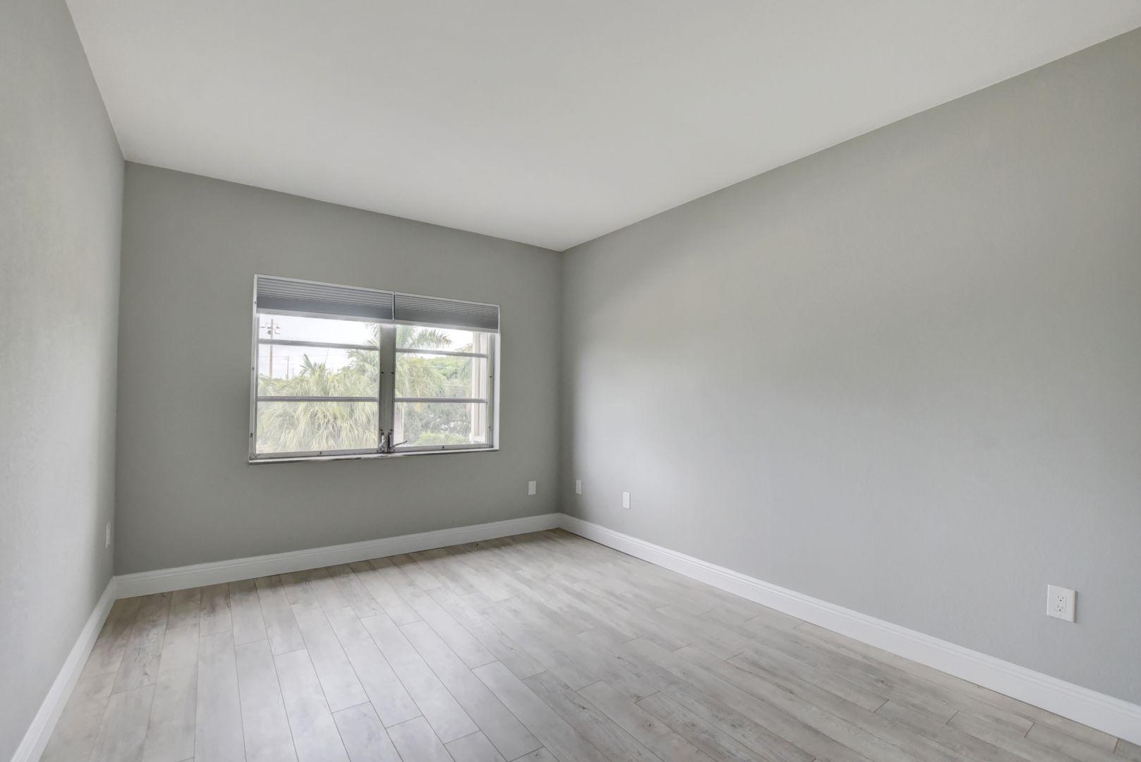 290 West Palmetto Park Road, Unit 304 Boca Raton, FL 33432 - Photo 12 of 27 an empty room with wooden floor and windows