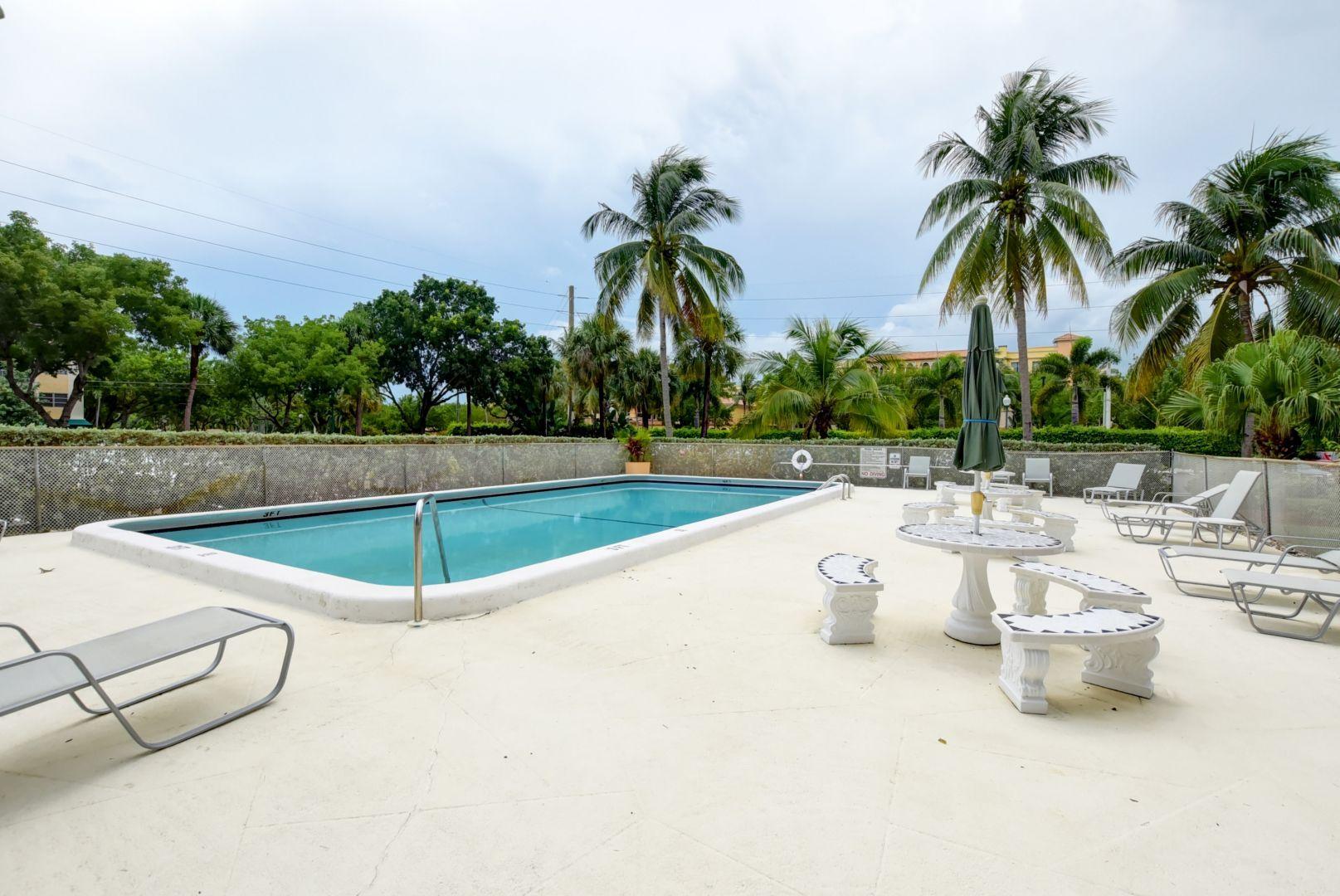 290 West Palmetto Park Road, Unit 304 Boca Raton, FL 33432 - Photo 26 of 27 a view of a swimming pool with a patio and a garden