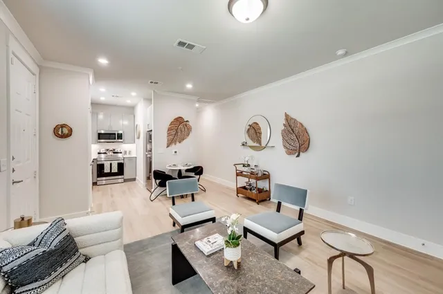 a living room with furniture kitchen view and a window