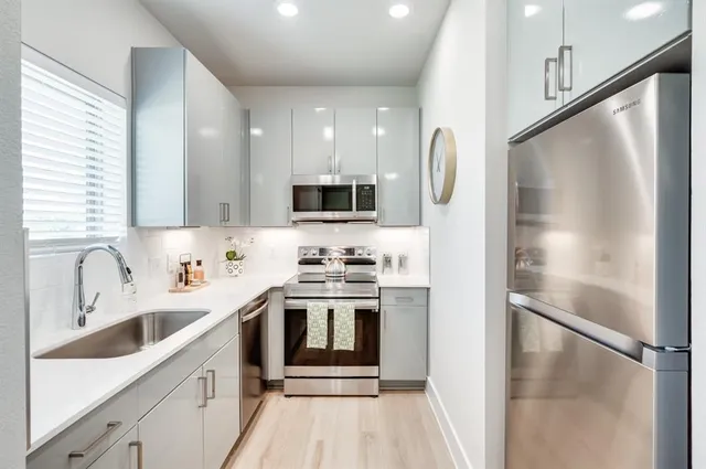 a kitchen with a sink stainless steel appliances and cabinets