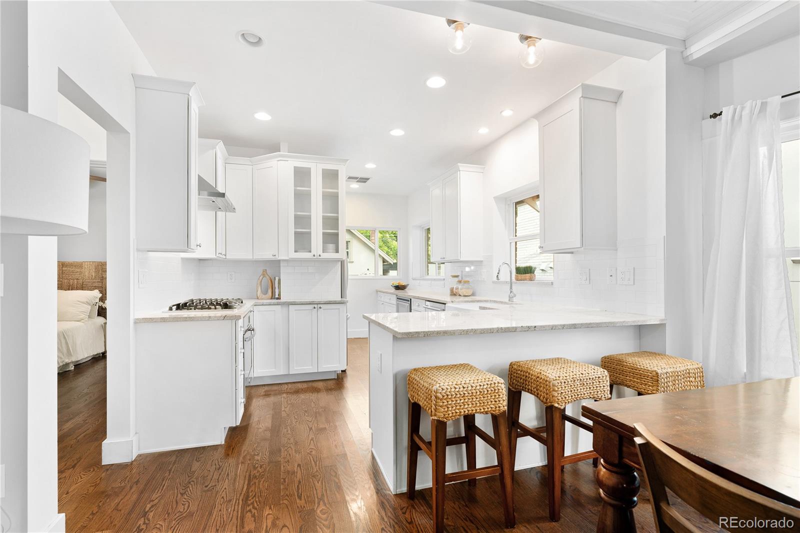 486 South Corona Street Denver, CO 80209 - Photo 12 of 46 a kitchen with white cabinets and chairs