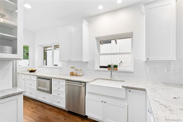 a kitchen with white cabinets and white appliances