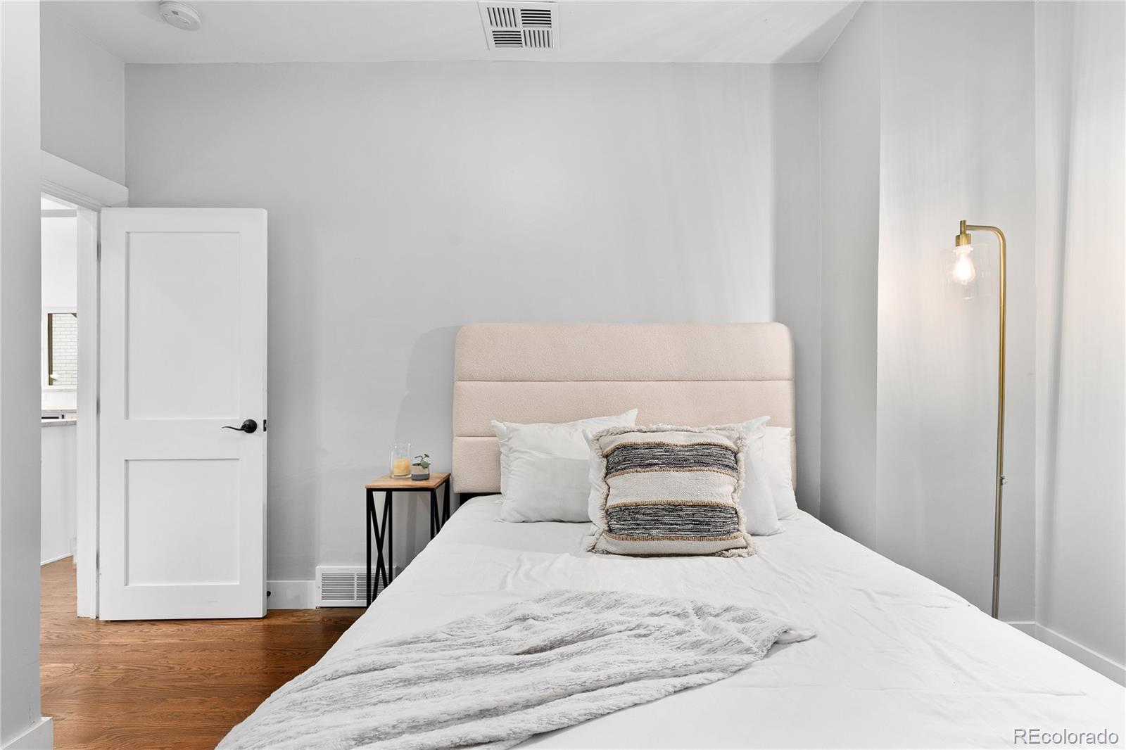 486 South Corona Street Denver, CO 80209 - Photo 21 of 46 a bedroom with a bed and wooden floor