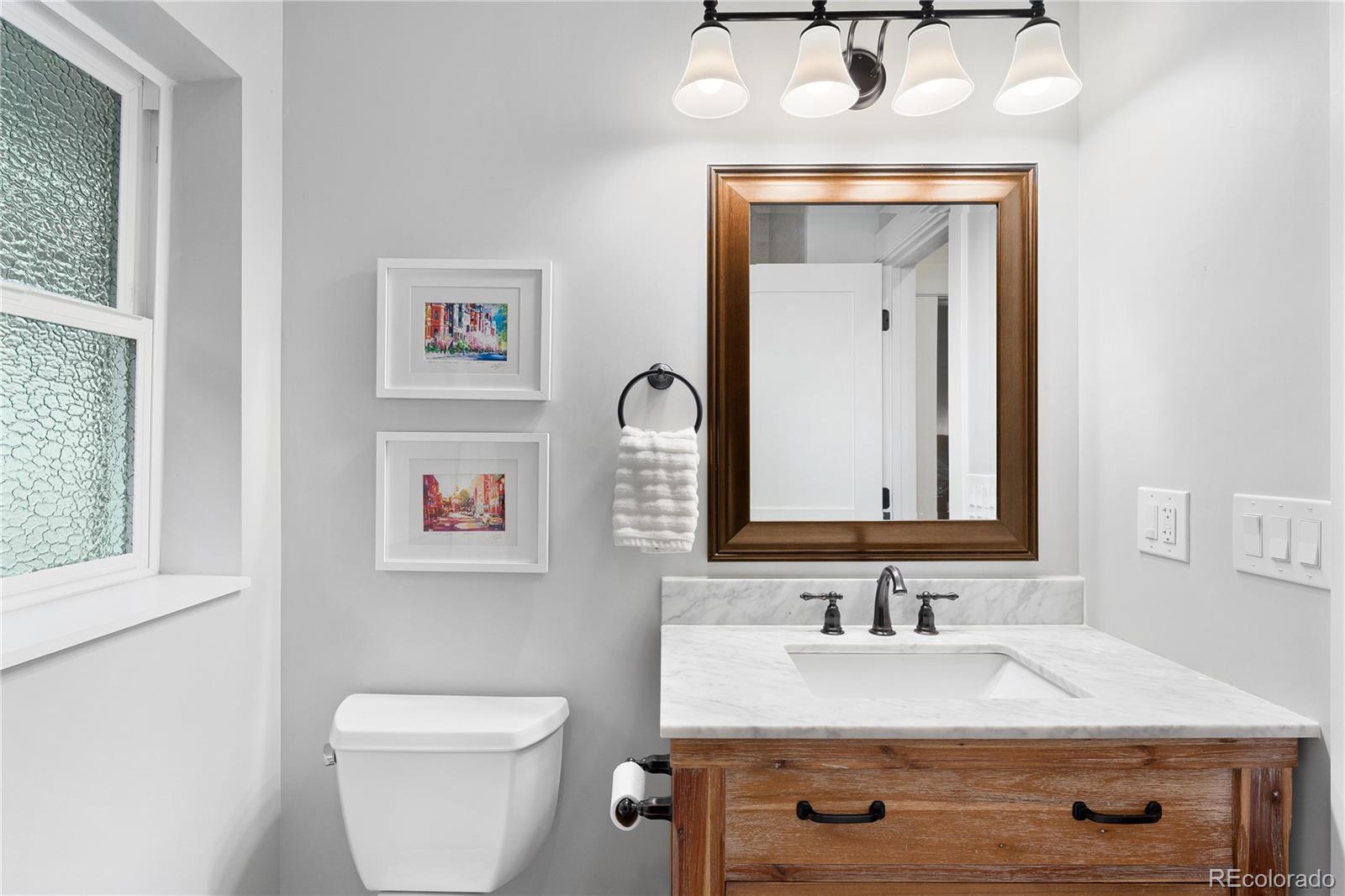 486 South Corona Street Denver, CO 80209 - Photo 23 of 46 a bathroom with a granite countertop sink vanity mirror and toilet