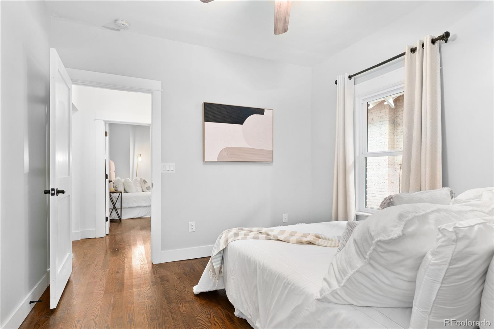 486 South Corona Street Denver, CO 80209 - Photo 25 of 46 a bedroom with a bed and wooden floor
