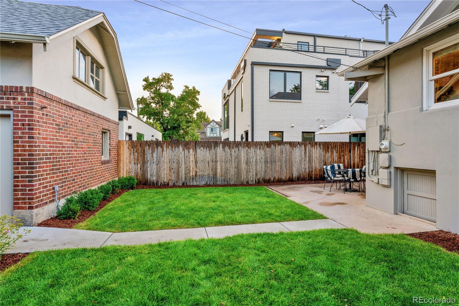 486 South Corona Street Denver, CO 80209 - Photo 36 of 46 a view of backyard with table and chairs and wooden fence