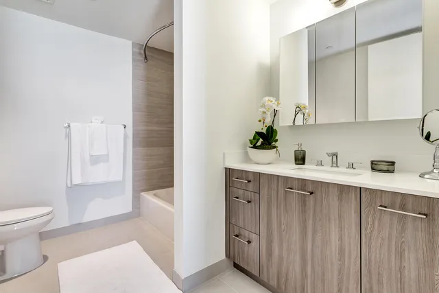 a bathroom with a tub a sink and a mirror