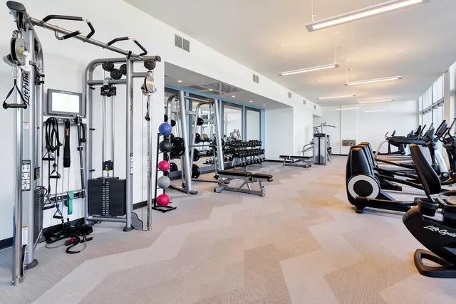 a view of a room with gym equipment and floor to ceiling window