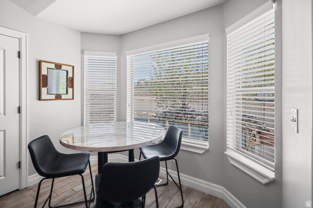 1588 West Rim Rock Drive Stockton, UT 84071 - Photo 10 of 61 Corner windows with white blinds, wood-finish flooring, and a white interior door
