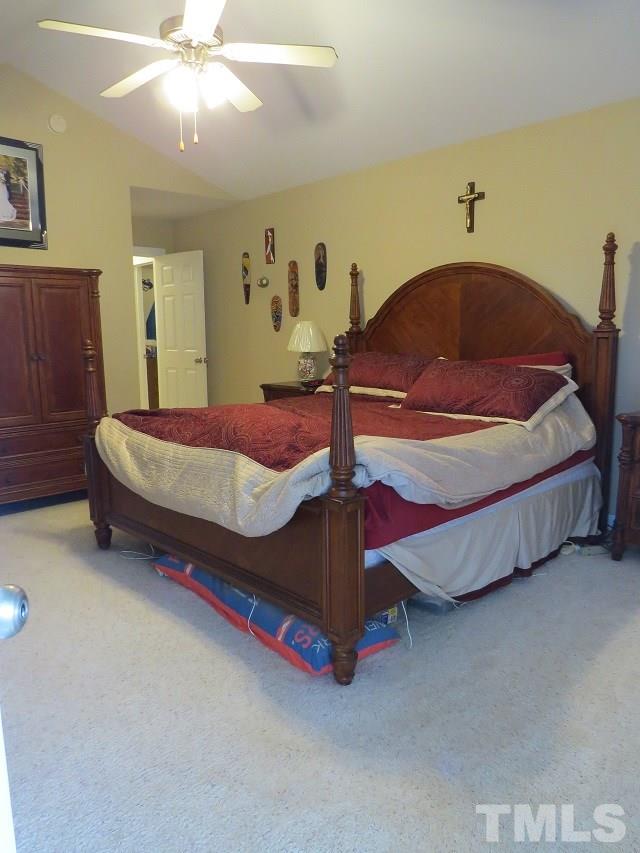 235 Steve Ridge Willow Spring, NC 27592 - Photo 11 of 25 a bedroom with a bed and a chandelier