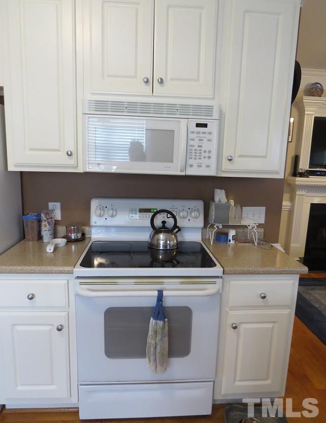 235 Steve Ridge Willow Spring, NC 27592 - Photo 6 of 25 a kitchen with white cabinets and appliances