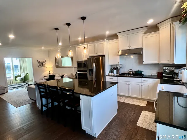 a kitchen with stainless steel appliances granite countertop a sink refrigerator and cabinets
