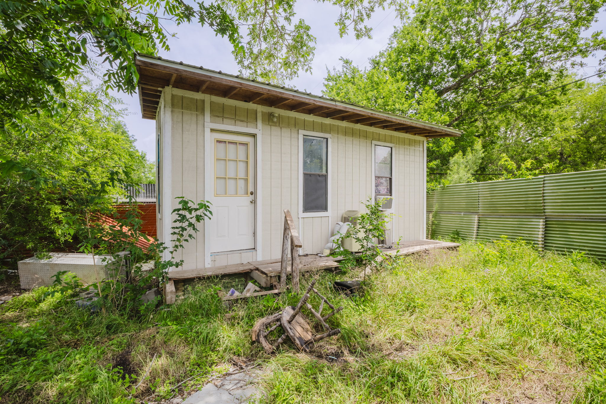 6803 Viewing Place Austin, TX 78719 - Photo 10 of 20 A quaint auxiliary structure is nestled amongst mature foliage, presenting potential for future use.