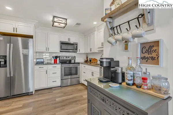 a kitchen with granite countertop a refrigerator stove and sink