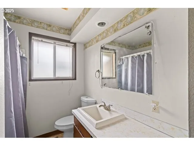 a bathroom with a sink mirror and toilet