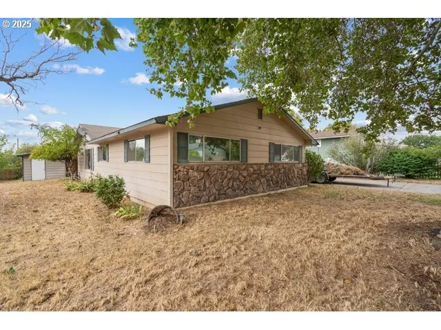 a view of a house with a yard and potted plants