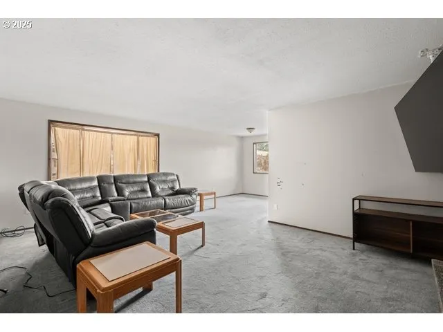 a living room with furniture a window and a flat screen tv
