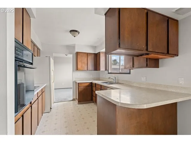 a kitchen with stainless steel appliances granite countertop a sink refrigerator and cabinets