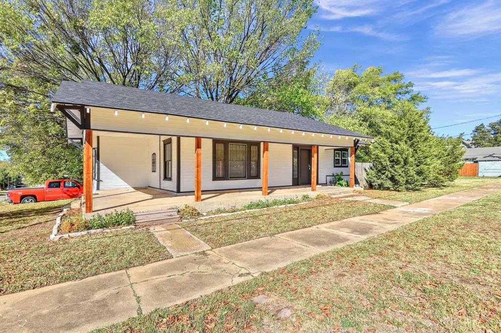 1115 South Rusk Avenue Denison, TX 75020 - Photo 2 of 21 a view of a house with a yard and garage