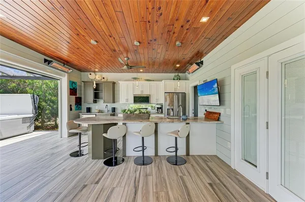 a view of a patio with table and chairs potted plants with wooden floor and fence
