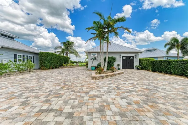 a view of a house with palm trees and a pathway