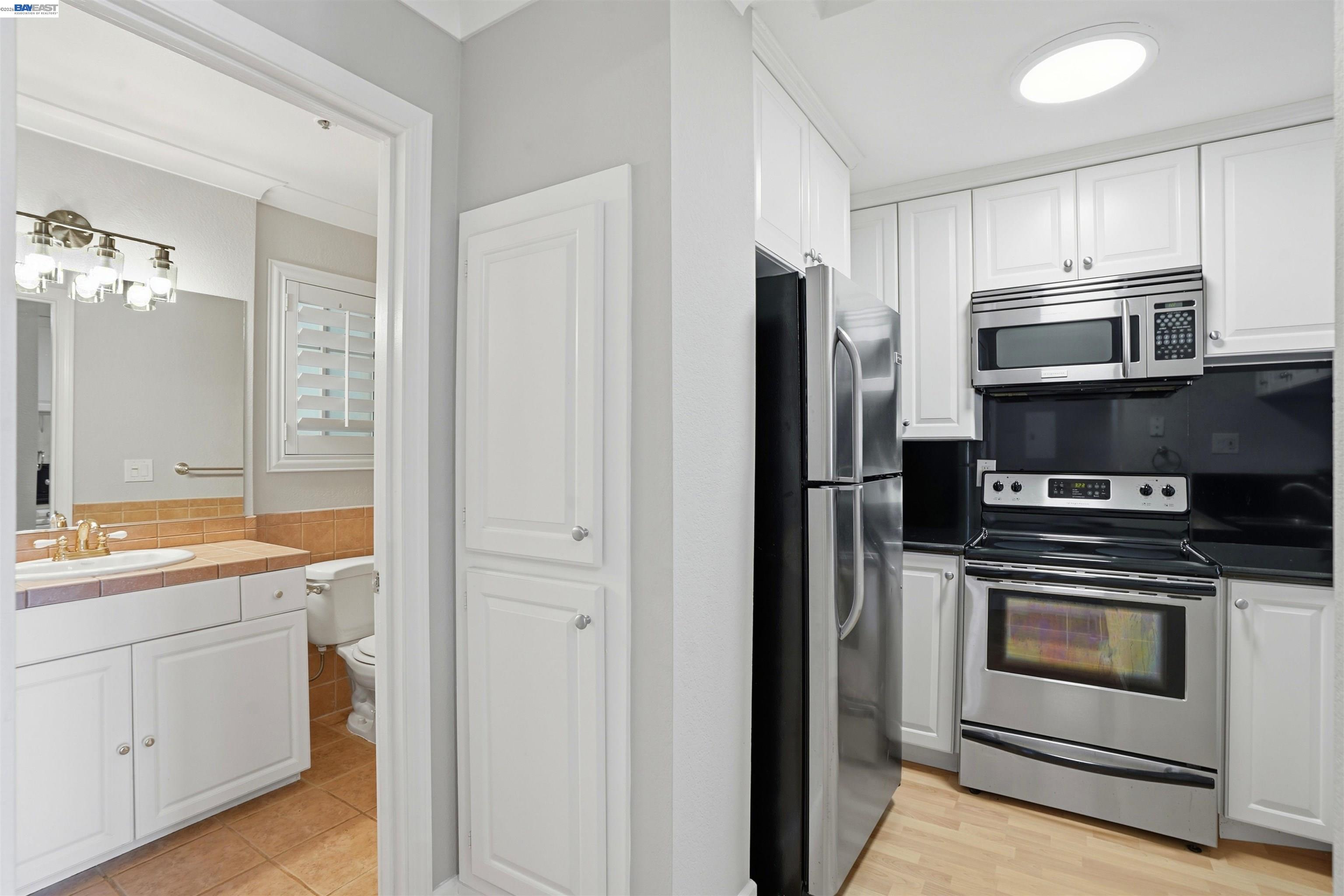 735 Watson Canyon Court, Unit 218 San Ramon, CA 94582 - Photo 6 of 18 a kitchen with white cabinets and stainless steel appliances