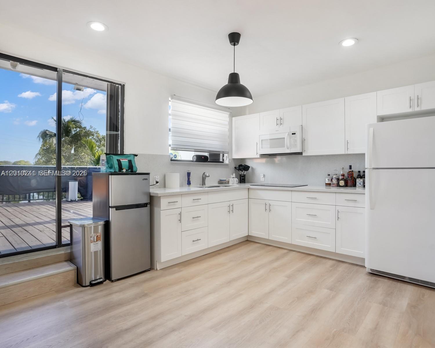 5629 Southwest 7th Street Miami, FL 33144 - Photo 11 of 15 a kitchen with white cabinets and white appliances