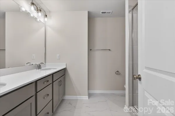 a bathroom with a double vanity sink a mirror and a shower