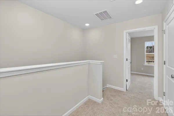a view of a hallway with wooden floor and entryway