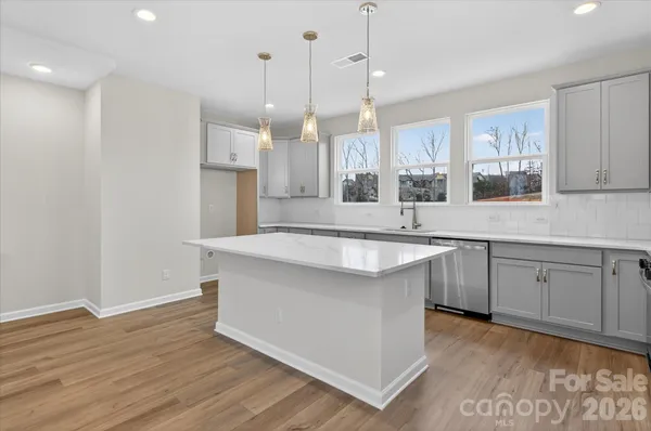 a kitchen with a sink cabinets stainless steel appliances and a window