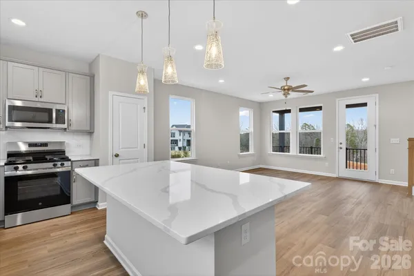a large kitchen with kitchen island a large counter space a sink appliances and cabinets
