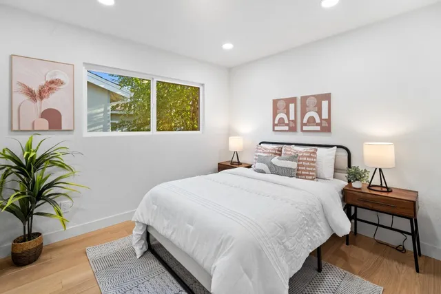 a bedroom with a bed and a potted plant