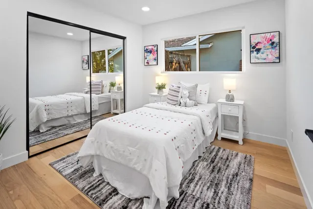 a bedroom with a large bed and a mirror