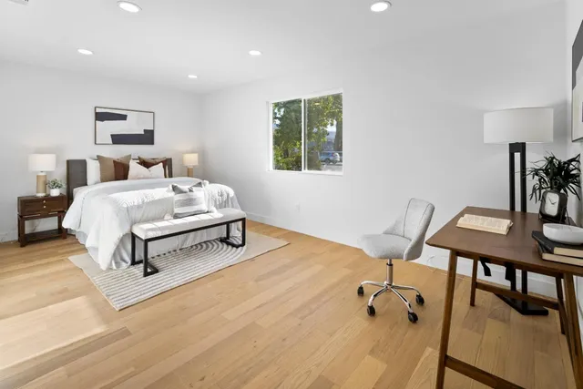 a bedroom with a bed a desk and chair